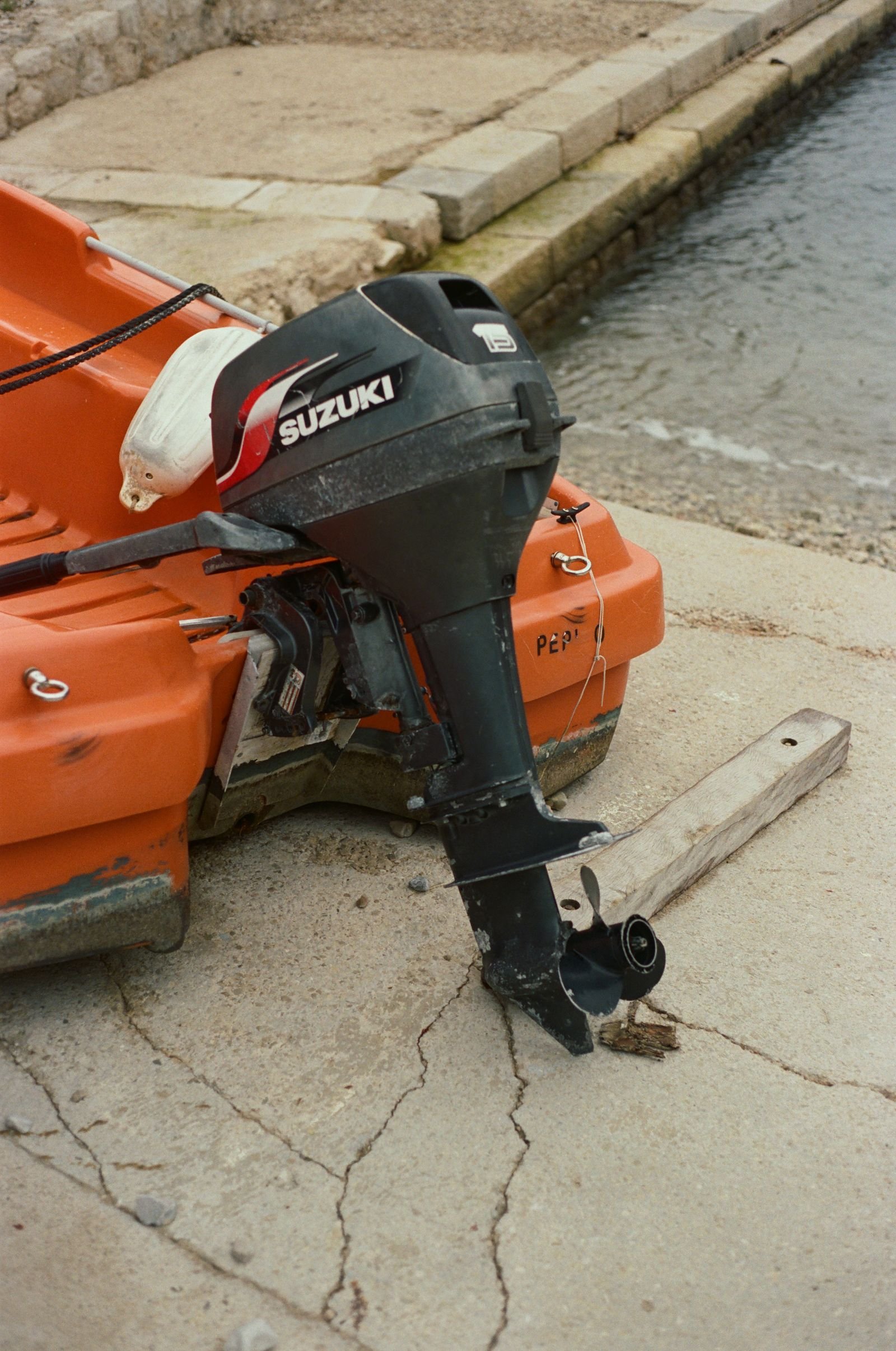 Moteur hors-bord et canot orange sur le quai